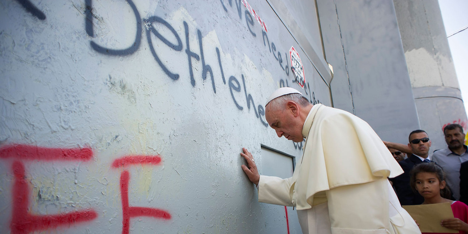 Pope Francis touches the wall on his way to celebrate a mass in Manger Square, in the Palestinian city of Bethlehem