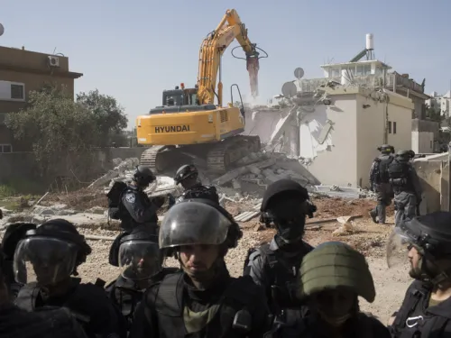 Israeli authorities use a Hyundai bulldozer to destroy the home of a Palestinian citizen of Israel in the town of Lydd, Feb 10 2015. The house belonged to a single mother and her four children. (Oren Ziv, ActiveStills)