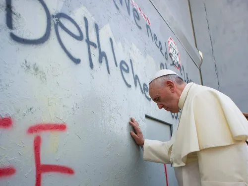 Pope Francis touches the wall on his way to celebrate a mass in Manger Square, in the Palestinian city of Bethlehem