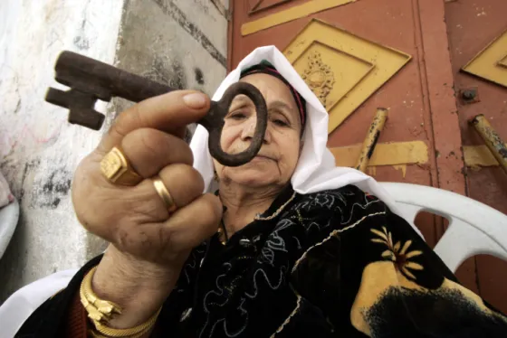 Palestinian woman holding a key, a symbol of the right of return for Palestinian refugees