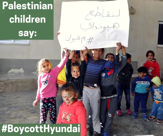 Children from the village of Umm al-Hiran, facing the imminent demolition of their homes by Israeli authorities using Hyundai bulldozers, carry signs saying, "Let's boycott Hyundai  #UmmAl-Hiran" (Credit: Sahar Rouhana, 2017)